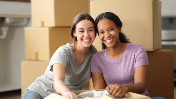 Happy roommates posing moving home